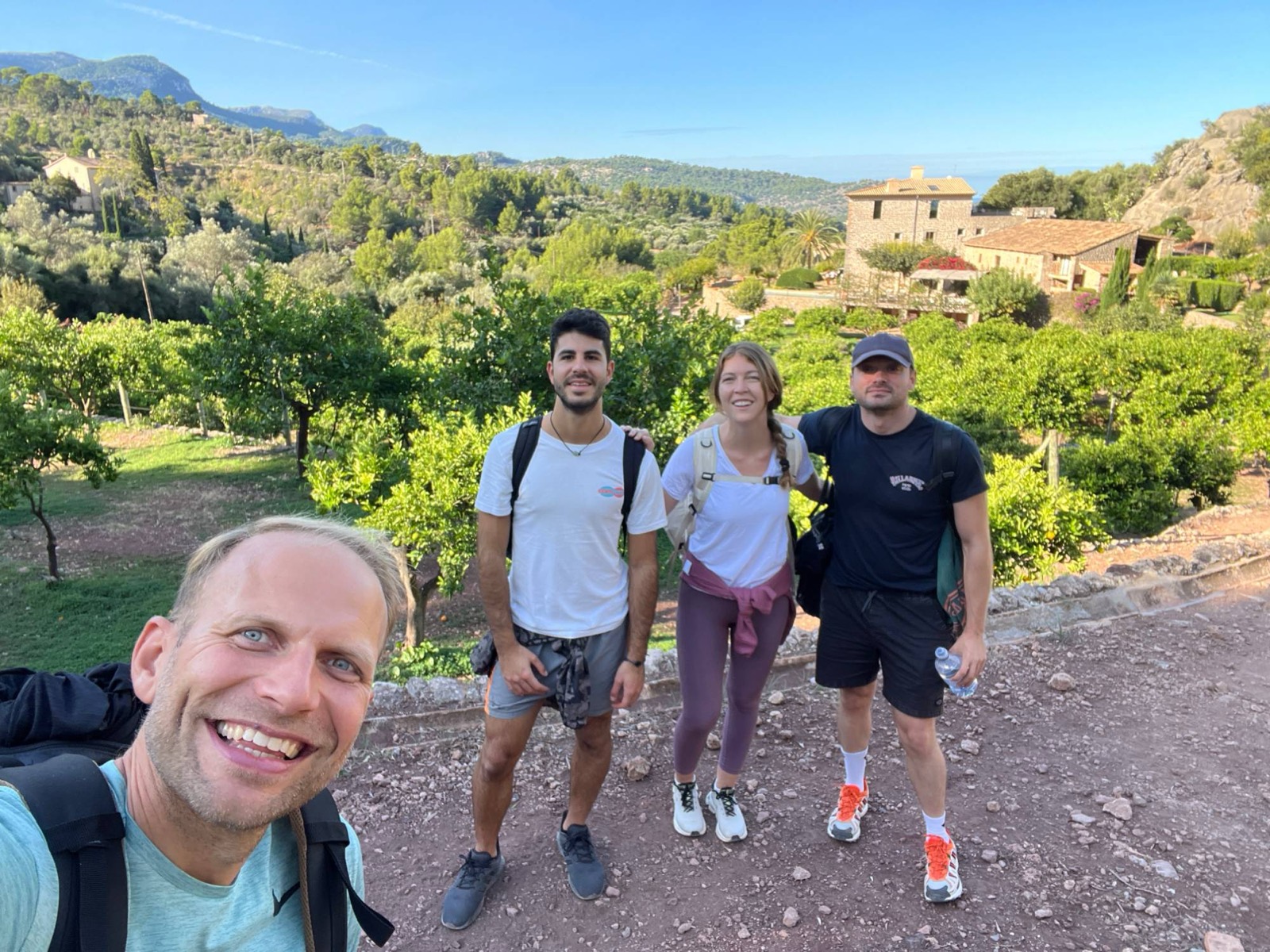 Small group on a trail between orange groves